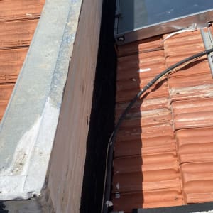 איטום גג עם חומר שחור בין אריחים