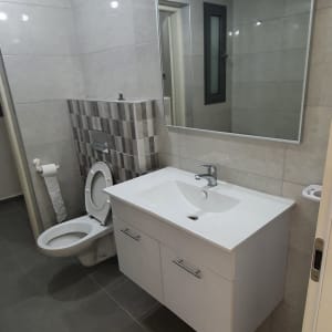 חדר אמבטיה עם כיור, מראה ואסלה פתוחה