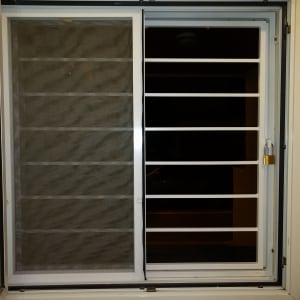 חלון עם מסגרת מתכת ורשת הגנה