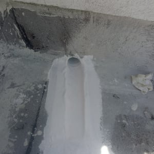 צינור על גג עם תיקון בטון סביבו