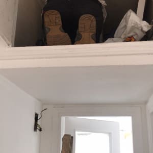 אדם על סולם עם חוטי חשמל חשופים בקיר