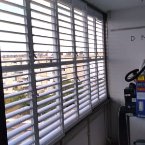 תריסי אלומיניום לבנים על חלון גדול