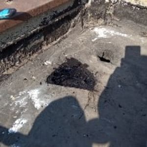 אזור אטימה עם חומר שחור על משטח בטון