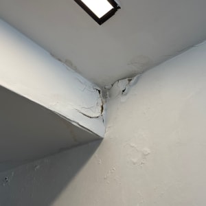קיר גבס עם סדקים ונזקי רטיבות בפינה