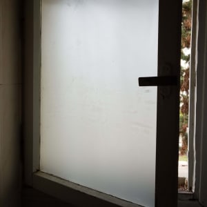 חלון זכוכית חלבית פתוח עם מסגרת מתכת