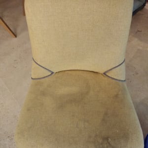 כיסא בד עם כתמים כהים על המושב