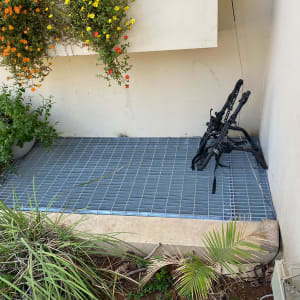 רשת מתכת על הרצפה עם מסגרת שחורה בצד