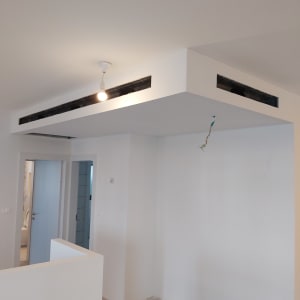 תקרת גבס עם תאורה תלויה וחוטי חשמל חשופים