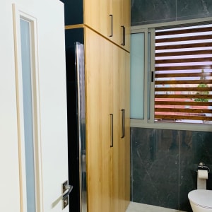 ארון עץ עם ידיות מתכת בחדר אמבטיה