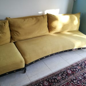 ספה צהובה עם כריות על רצפת אריחים