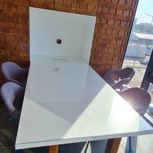 שולחן זכוכית עם רגלי עץ בחדר מואר