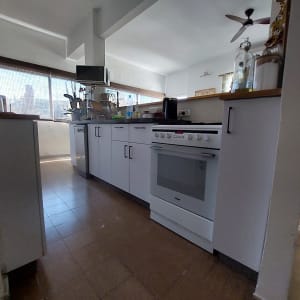 מטבח עם תנור לבן, ארונות וכלים על השיש