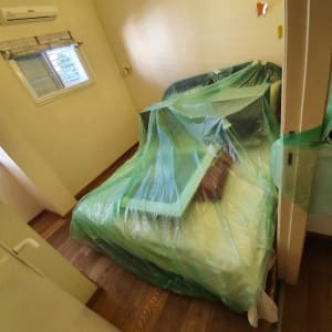 חדר עם רהיטים מכוסים בניילון לקראת צביעה