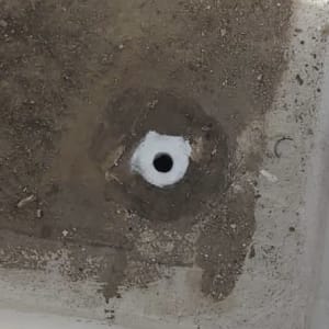 חור אטום עם חומר לבן על משטח בטון