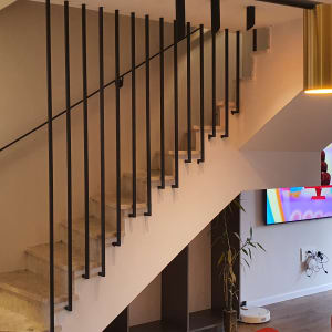 מעקה מתכת שחור על מדרגות אבן