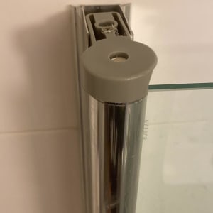 חלק ממסגרת זכוכית של מקלחון עם מחבר מתכת