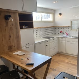 מטבח משופץ עם ארונות לבנים ומשטח עץ