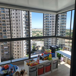 חדר עם צעצועים מסודרים על מדפים וקופסאות אחסון