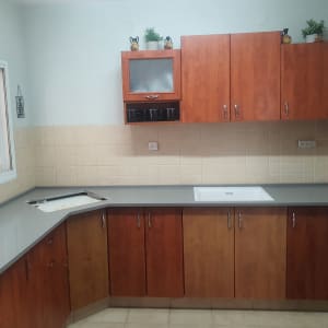 שיש אפור במטבח עם ארונות עץ וכיור לבן