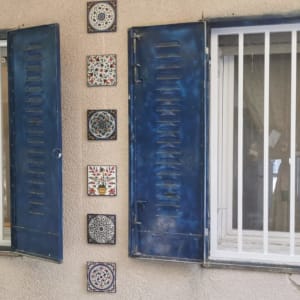 חלונות עם סורגים ומסגרות כחולות על קיר