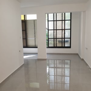 חדר ריק עם רצפת קרמיקה וחלונות גדולים