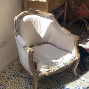 כורסה עם ריפוד בהיר על רצפה מעוטרת