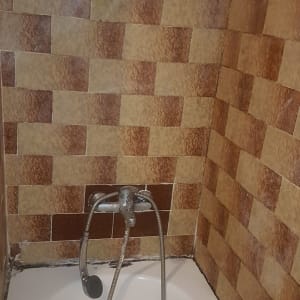 ברז אמבטיה עם צינור מקלחת על קיר אריחים