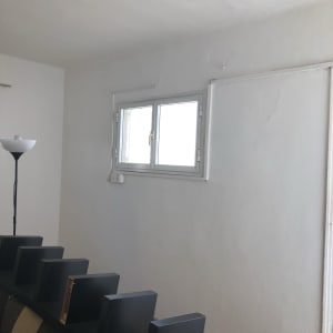 קיר צבוע בלבן עם חלון קטן