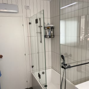 אמבטיה עם דלת זכוכית, מקלחון וברז שחור