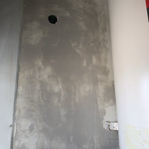 קיר אפור עם חור קטן, חלקית צבוע