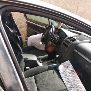 אדם מתקן מערכת ברכב עם לוח מחוונים פתוח