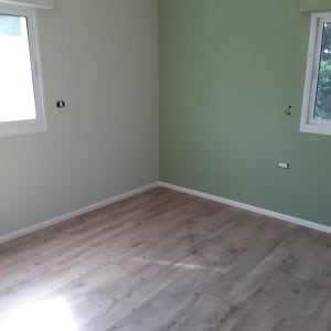 רצפת פרקט עץ בחדר עם קירות ירוקים