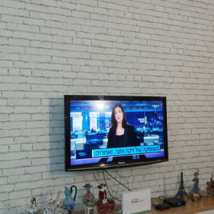 קיר לבנים לבן עם טלוויזיה תלויה