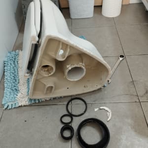 אסלה הפוכה עם אטמים וכלי עבודה על הרצפה