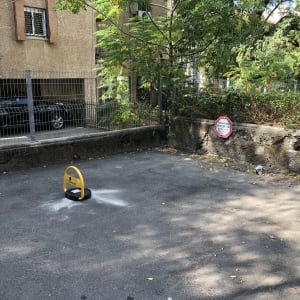 מחסום חניה חשמלי אישי מותקן על משטח אספלט בחניה