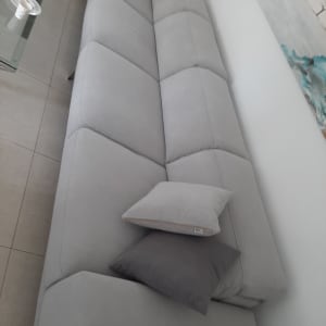 ספה אפורה עם כריות אפורות על ריפוד