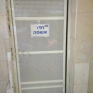 דלת מתכת מחוררת עם שלט חדר אשפה