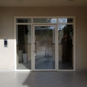 דלת זכוכית עם מסגרת אלומיניום בכניסה לבניין