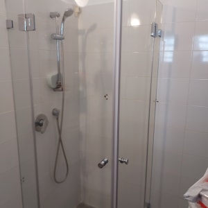 מקלחון זכוכית עם ראש מקלחת וכפתורי שליטה