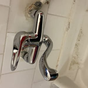 ברז כרום מותקן על קיר אריחים לבנים