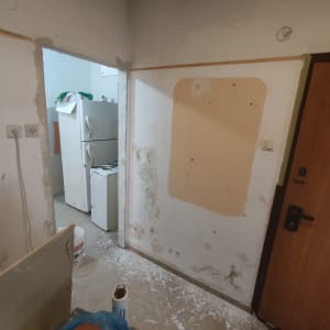 קיר עם סימני צבע ישנים, דלי צבע על הרצפה