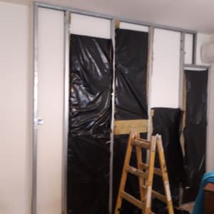 קיר גבס בבנייה עם מסגרת מתכת וסולם עץ