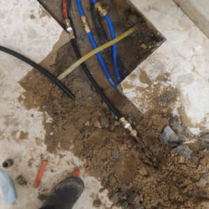 צינורות מים כחולים ושחורים בתיקון רצפה