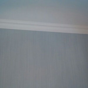 קיר צבוע בגוון אפור עם קרניז לבן