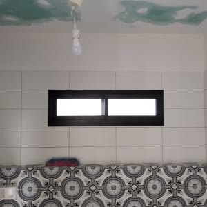 חלון אלומיניום שחור על קיר לבן