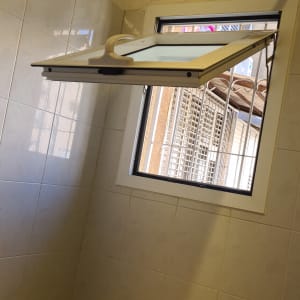 חלון אלומיניום פתוח עם מסגרת לבנה