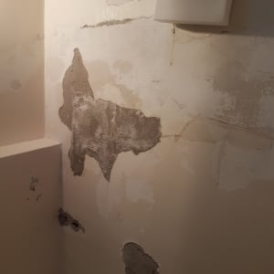 קיר עם קילופי צבע ותיקוני טיח חשופים