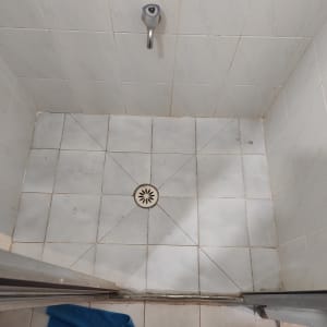 רצפת מקלחת עם ניקוז מרכזי ואריחים לבנים