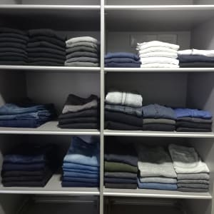 בגדים מקופלים בארון מסודר על מדפים