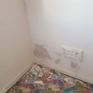 קיר צבוע חלקית עם תיקוני טיח ויריעות מגן על הרצפה